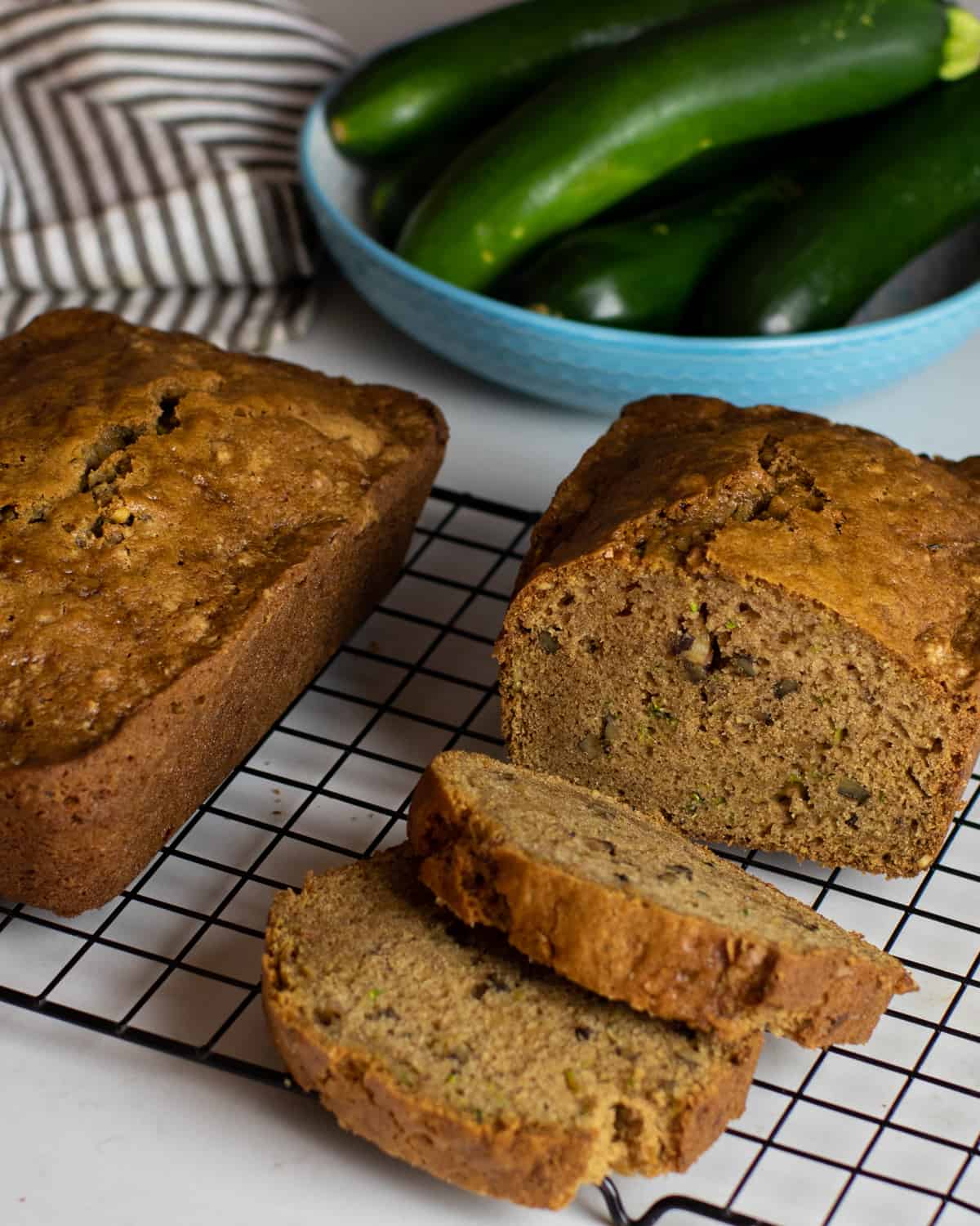 Zucchini bread with two slices cut and placed next to the loaf.