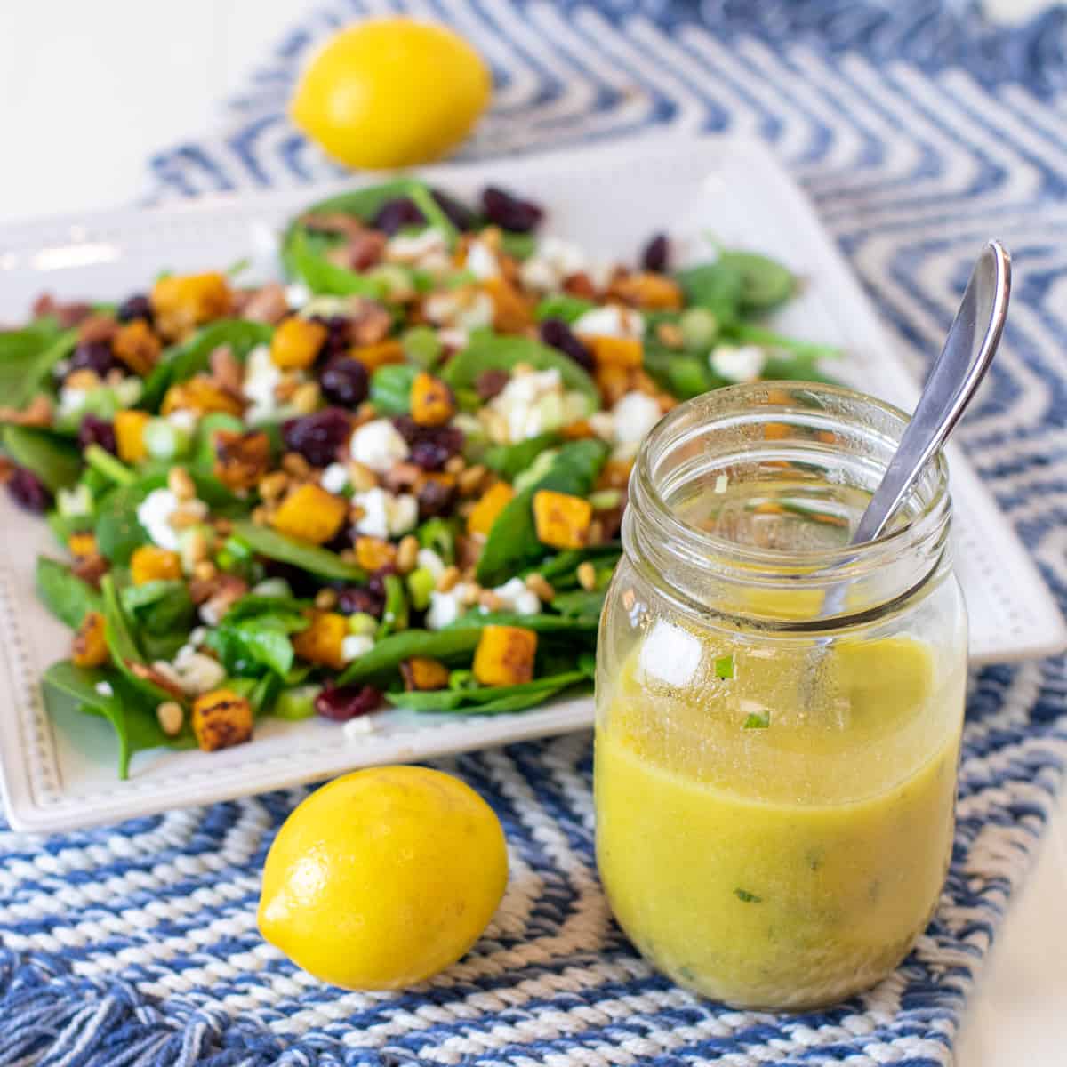 Overhead picture of salad on a plate with a jar of salad dressing.