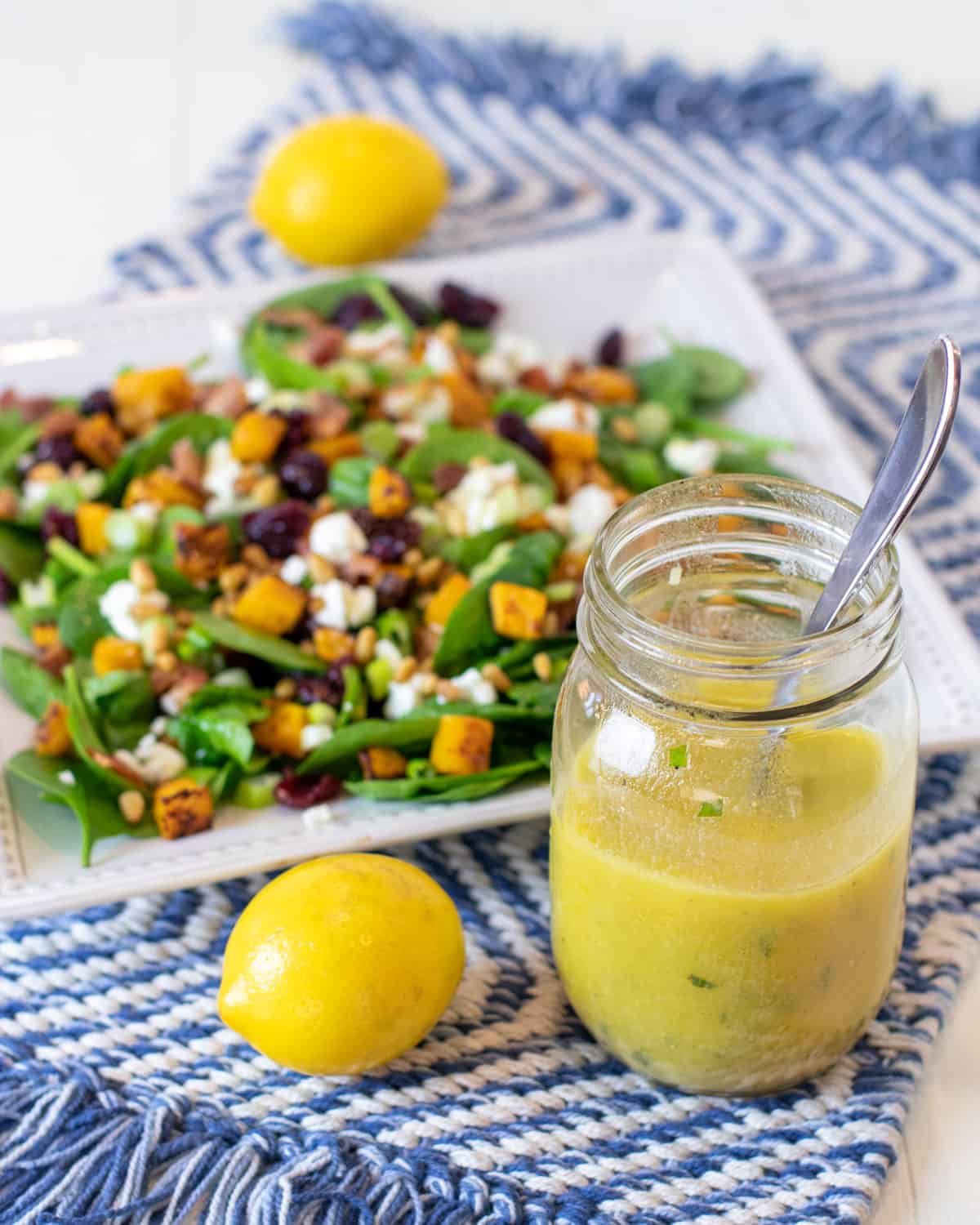 Overhead picture of a salad and a jar of lemon vinaigrette.