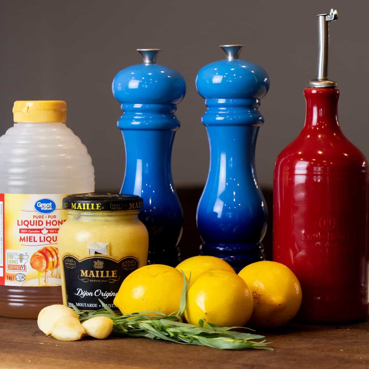 Ingredients of lemon salad dressing on a cutting board.