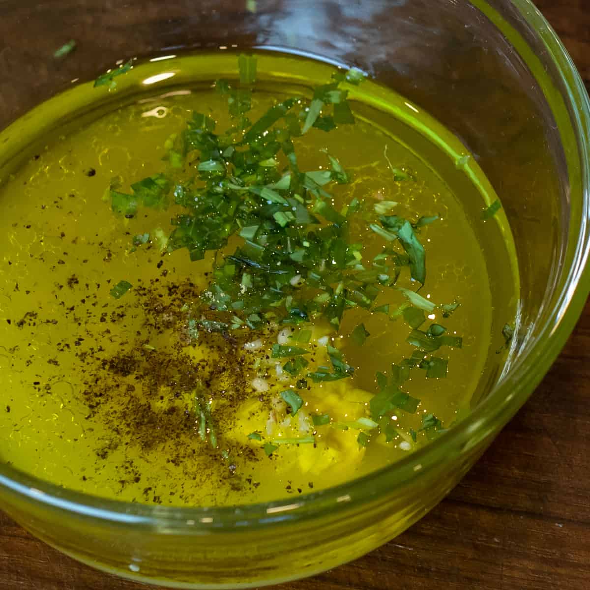 Ingredients for salad dressing measured and added to glass bowl.