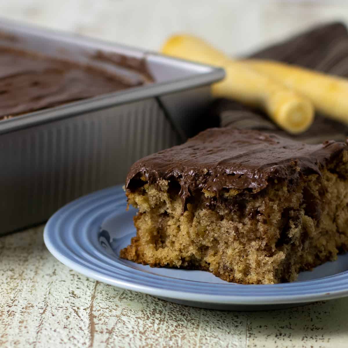 Parsnip cake with whole parsnips in the backround.