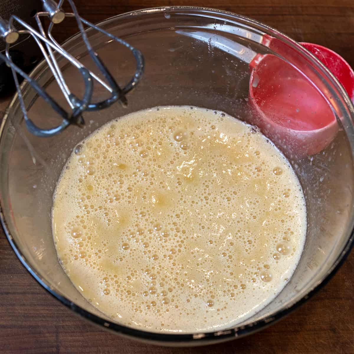 Wet ingredients mixed in a glass bowl.