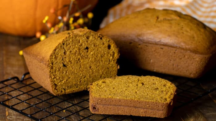 Two pumpkin loaves. One whole and one sliced.