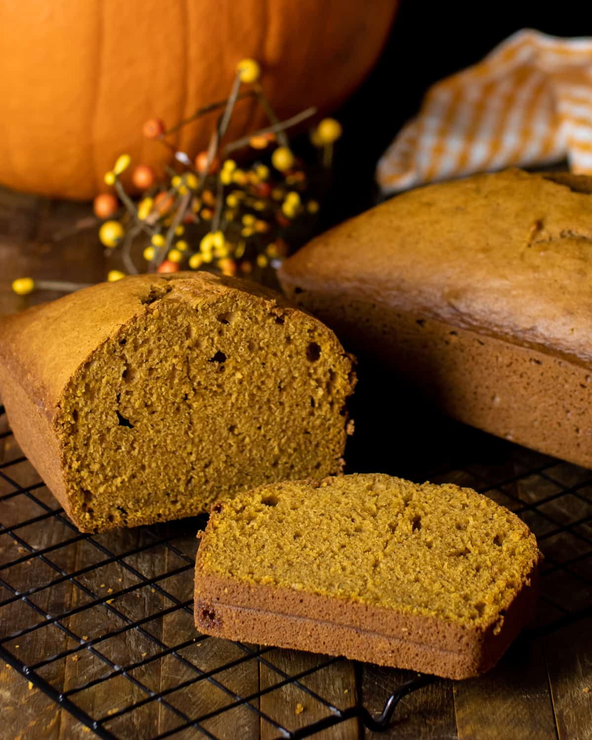 Two pumpkin loaves, one sliced and one whole.