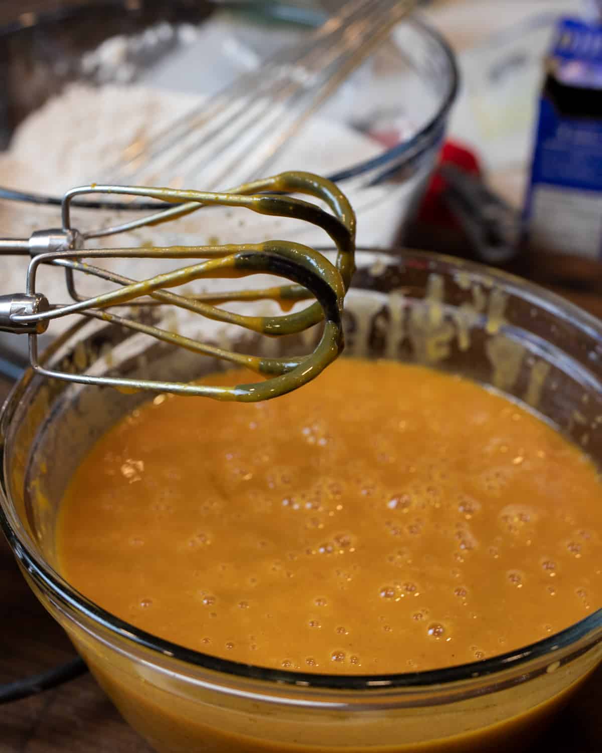 Wet ingredients beaten together in a glass bowl.