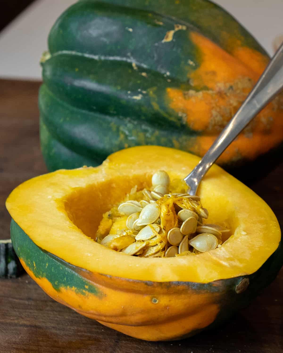 Seeds being scooped out of an acorn squash.