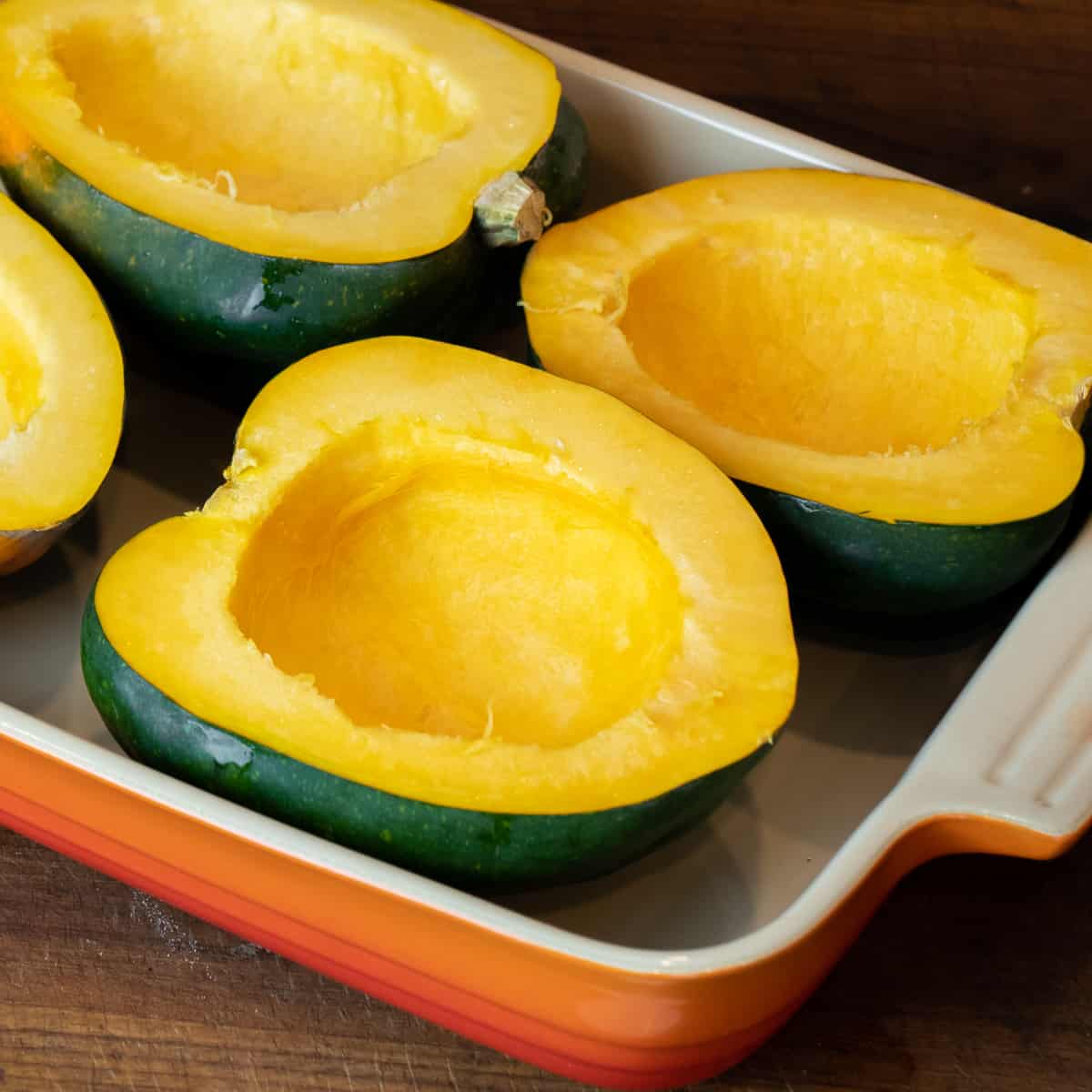 Cleaned out acorn squash halves in a baking dish.