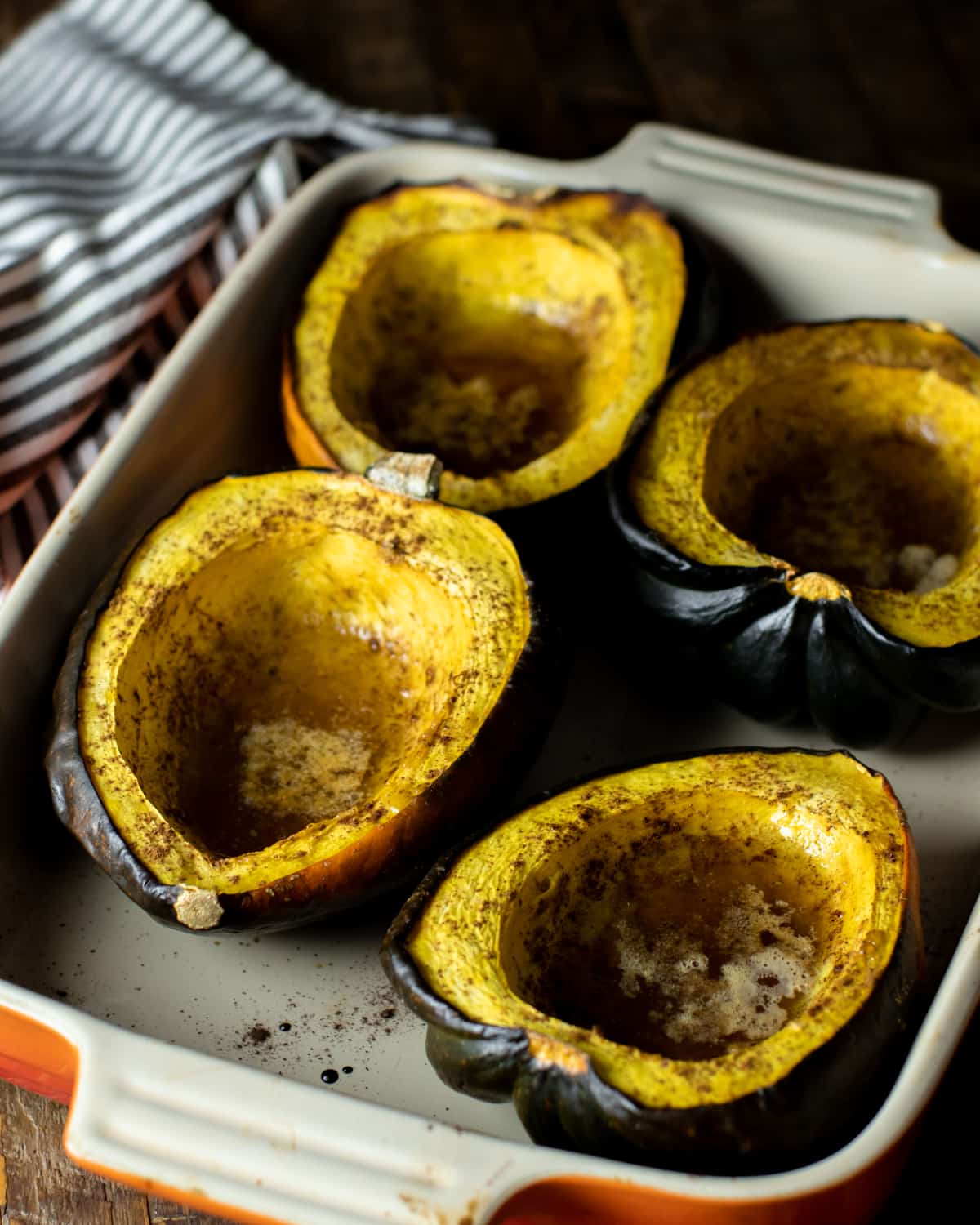 Roasted acorn squash in a rectangular baking dish.