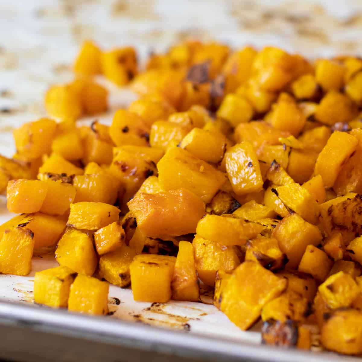 Roasted cubes of butternut squash piled together.