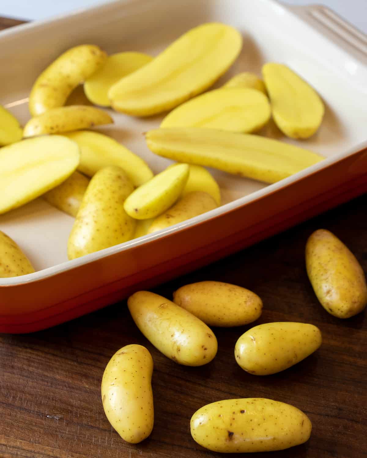 Raw potatoes with some whole and others cut in half.