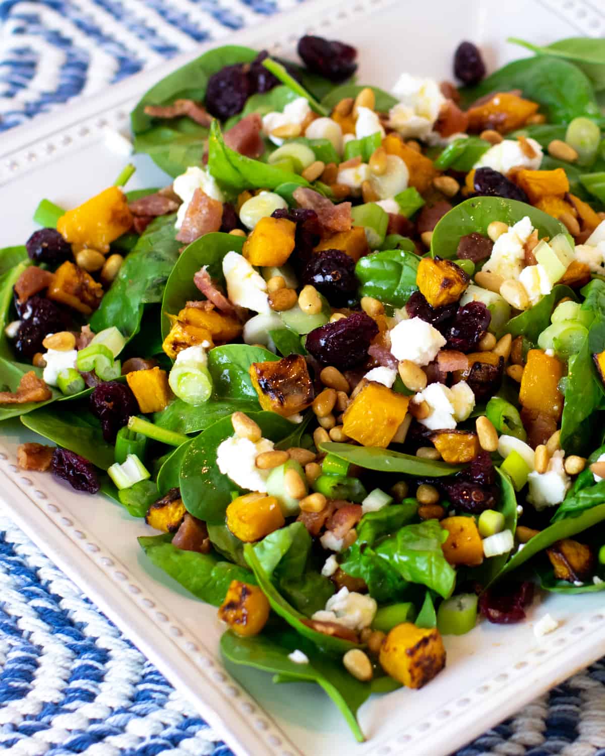 Spinach salad with butternut squash, bacon and cranberries.