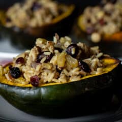 A close up with roasted squash half filled with stuffing.