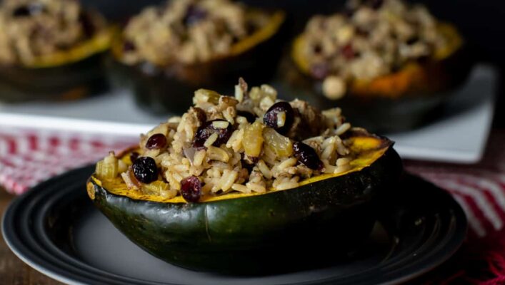A close up with roasted squash half filled with stuffing.