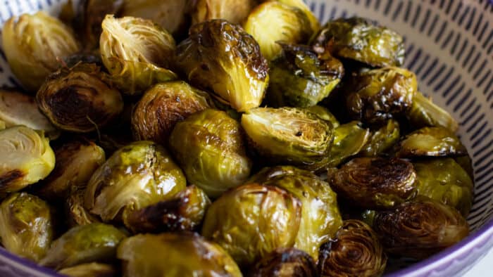 A shallow bowl piled with Brussels sprouts.