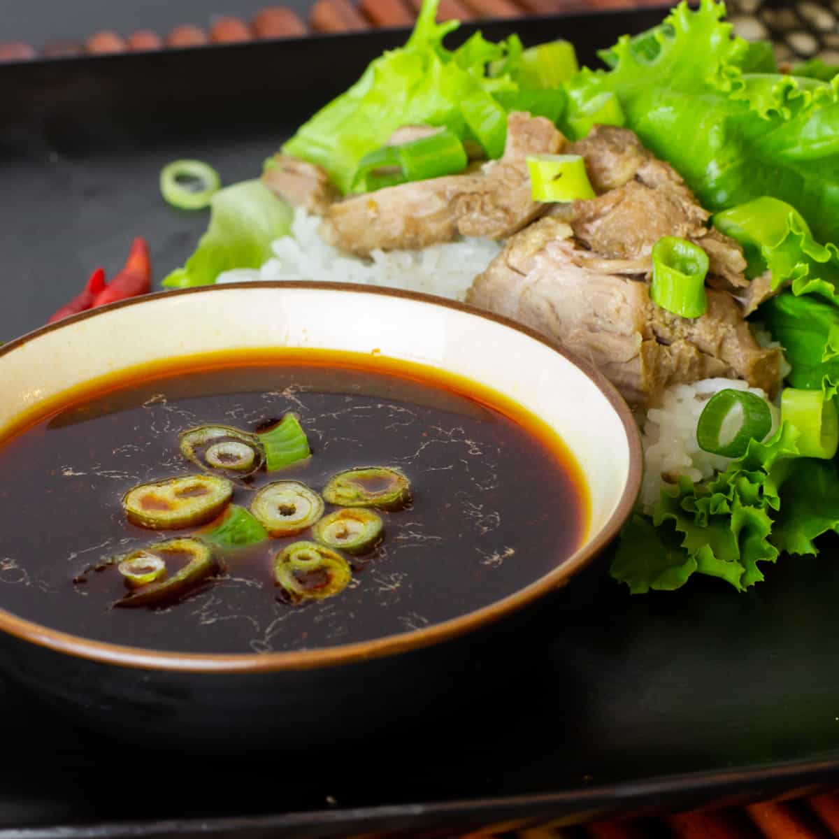 A plate with lettuce wraps and a bowl of sauce.