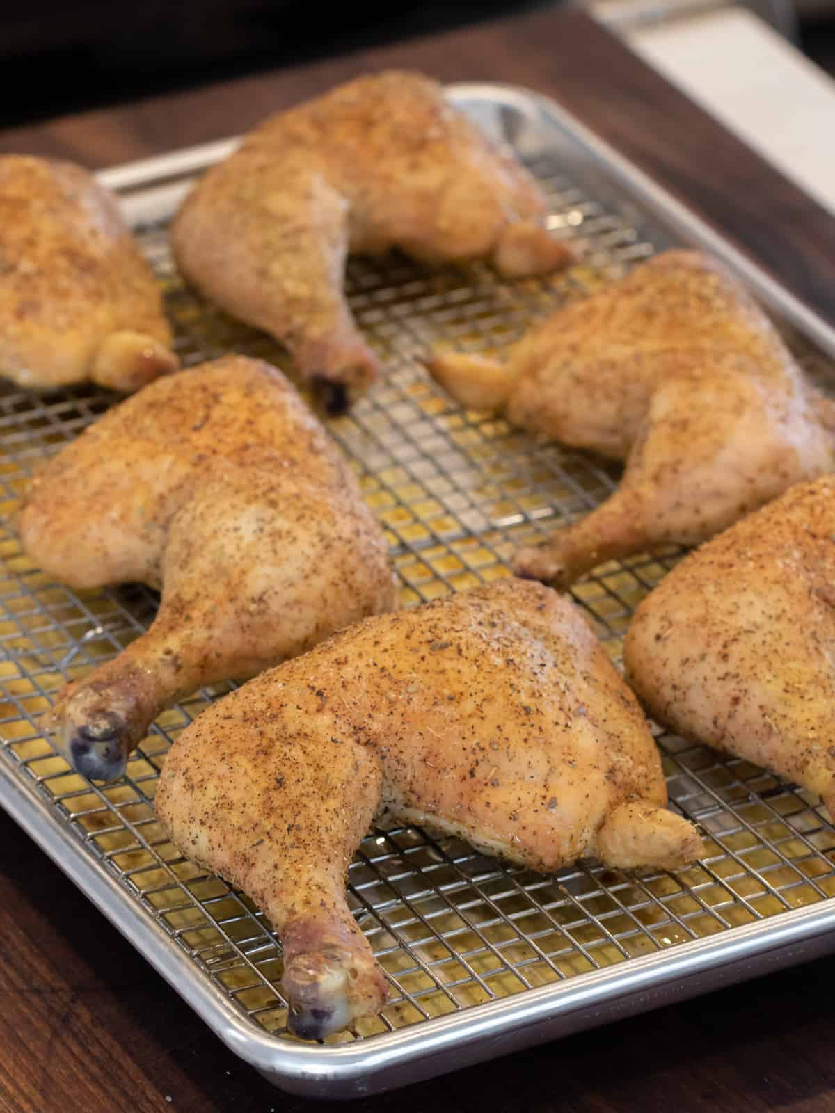 Overhead image of cooked chicken pieces on a baking sheet.