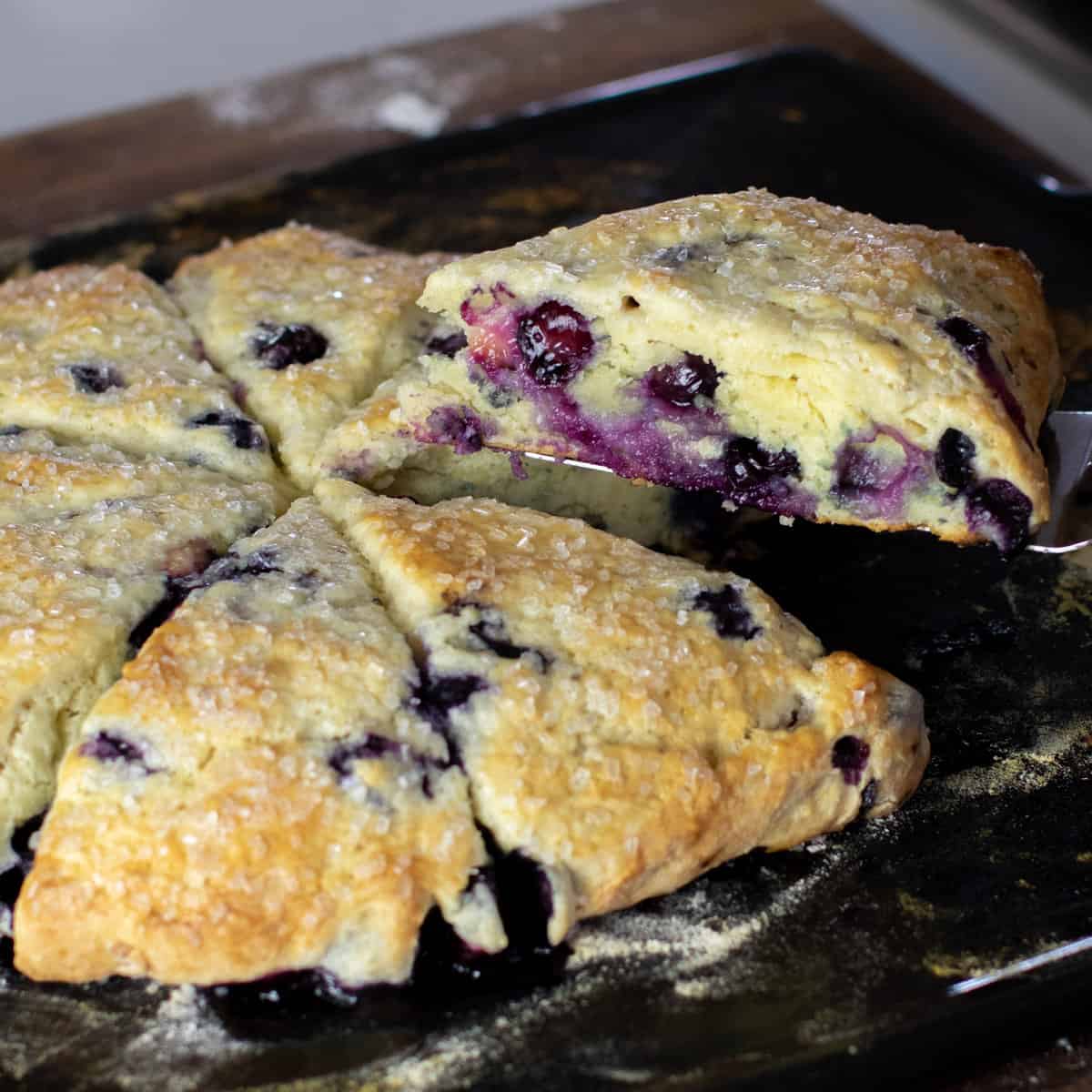 A scone wedge being lifted up off the baking stone.