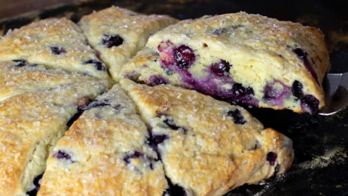 A slice of a scone being lifted off the baking stone.