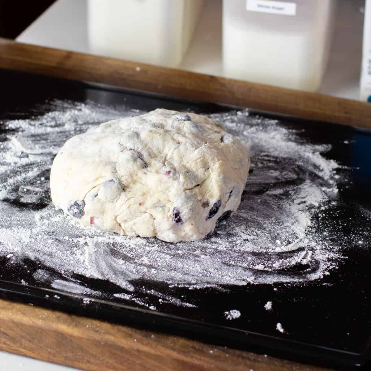 A ball of scone dough on a floured baking stone.