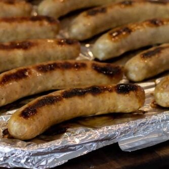 Cooked sausages on a baking sheet.