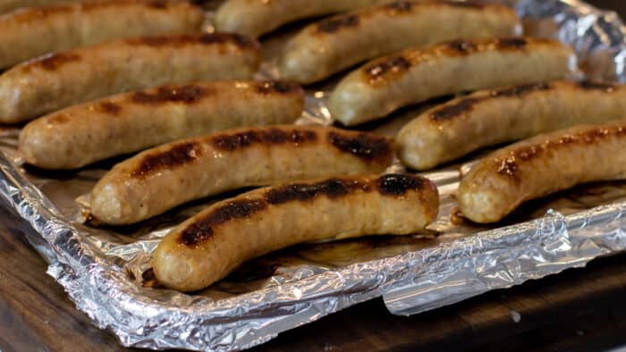 Cooked sausages on a baking sheet.