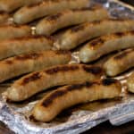 Cooked sausages on a baking sheet.