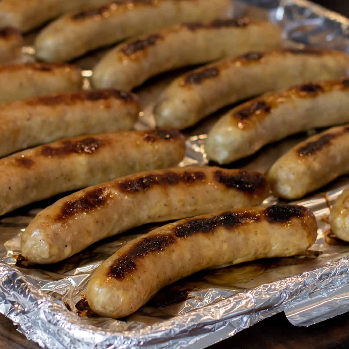 Cooked sausages on a baking sheet.