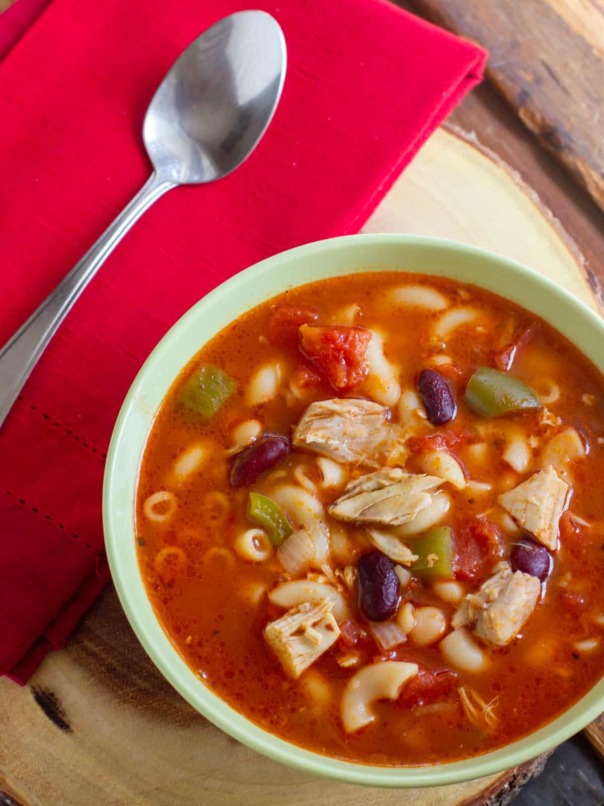 Bowl of minestrone on a wooden serving tray.