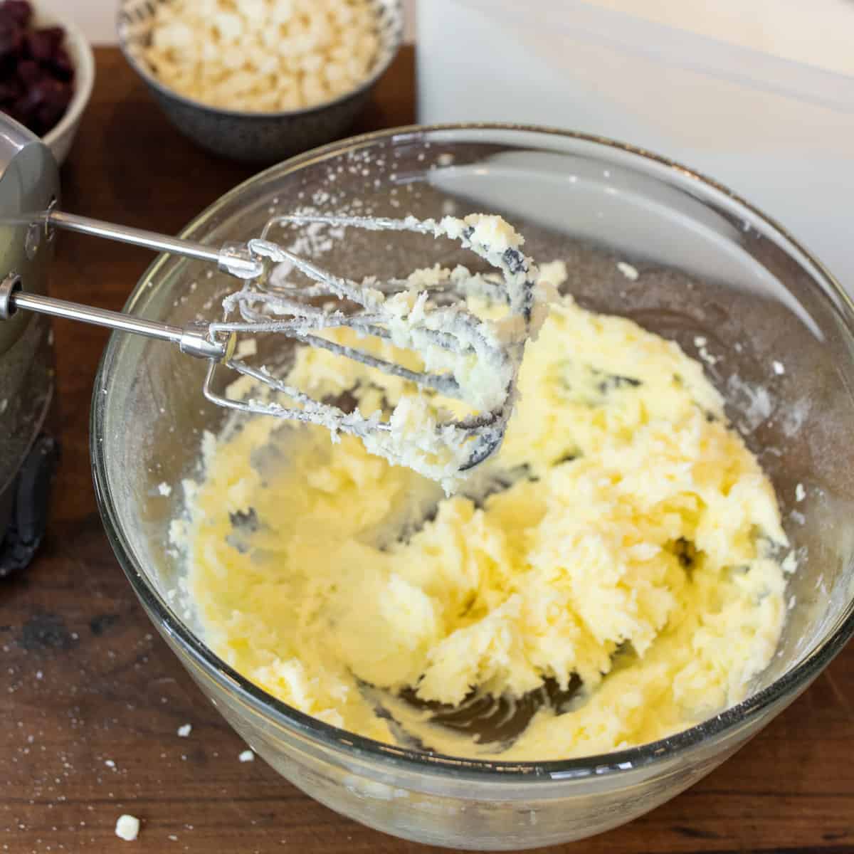 Butter and sugar mixed together in a glass mixing bowl.