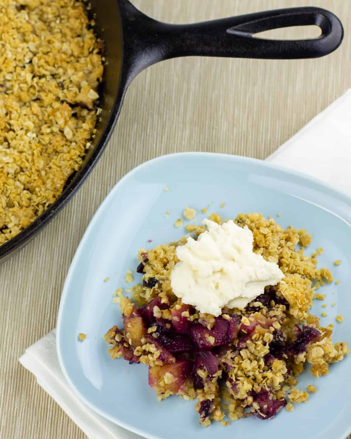 A plate and skillet of apple blueberry crumble.