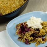 A close up of a serving of apple blueberry crumble on a plate.