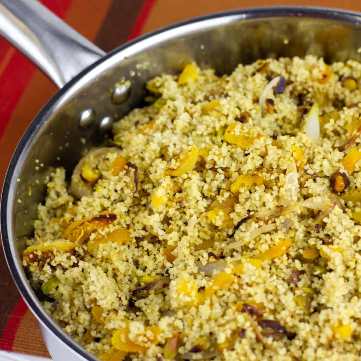 A saucepan with couscous and apricots.