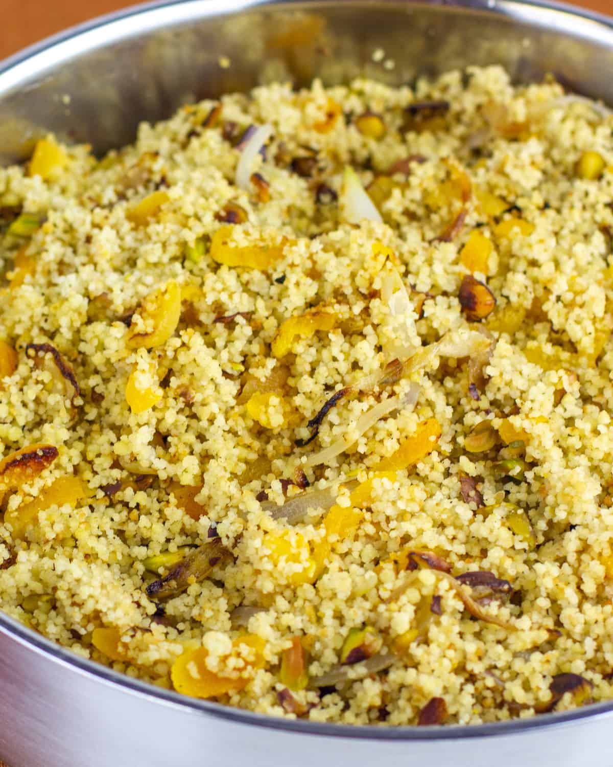 Close up picture of cooked couscous with onions and apricots.