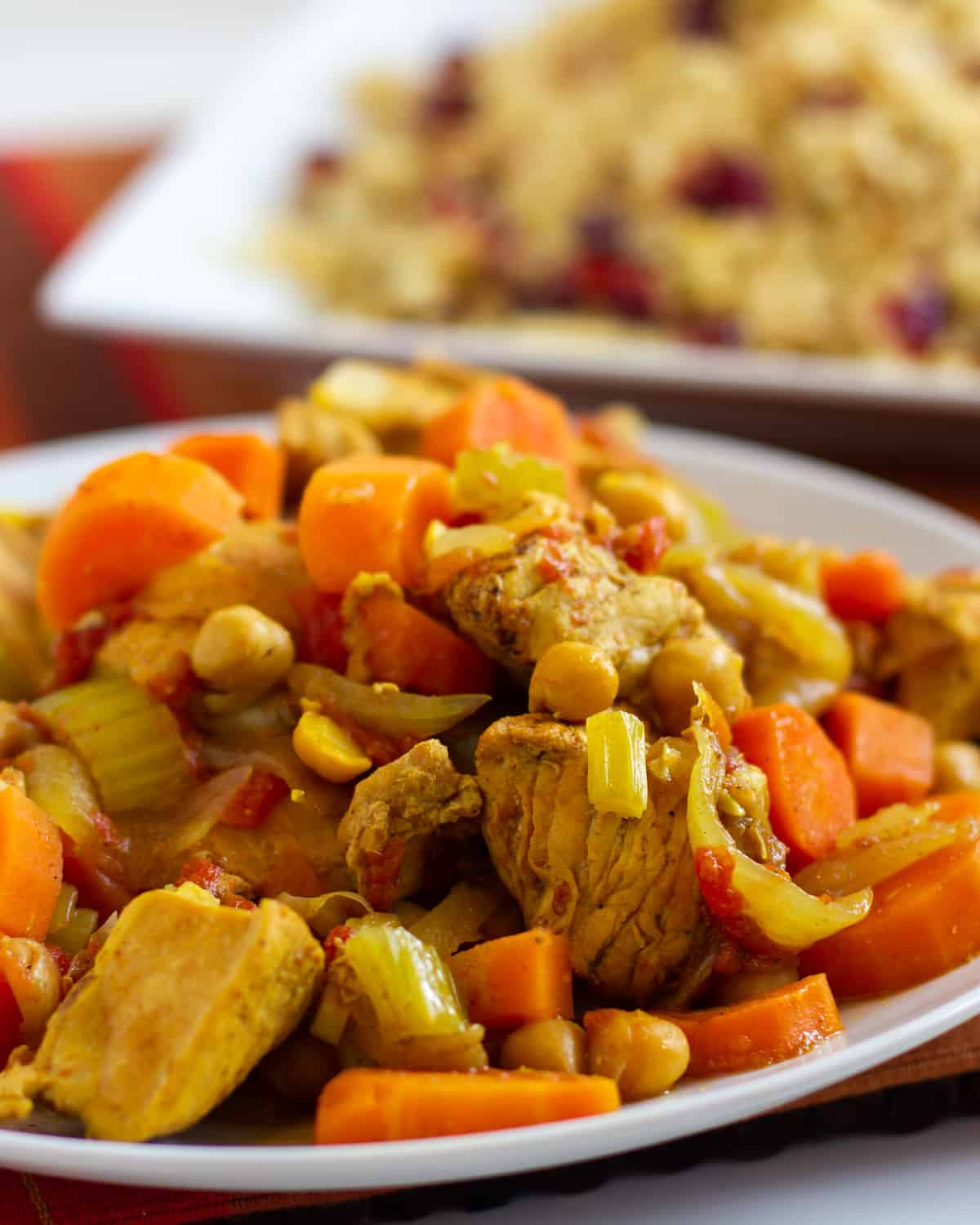 A dish with chicken, carrots and chick peas.