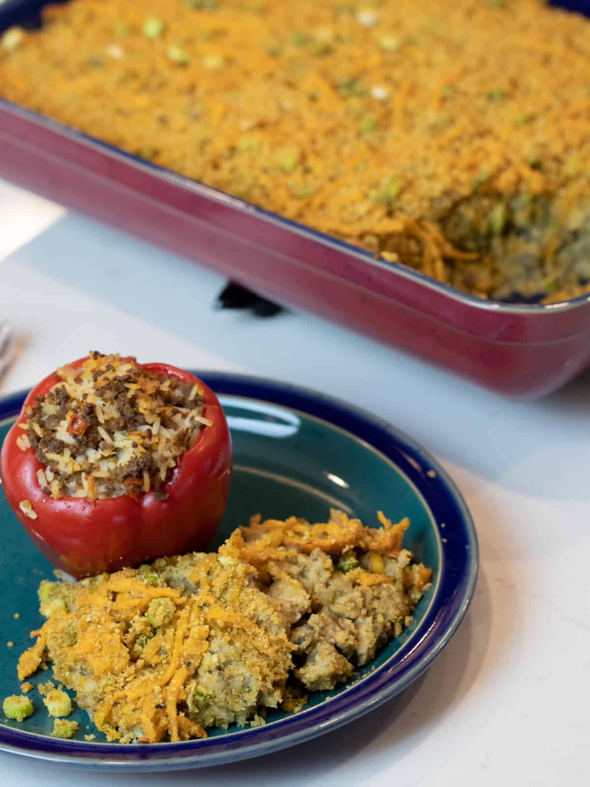 Overhead picture of a dinner plate with casserole and a stuffed red pepper.