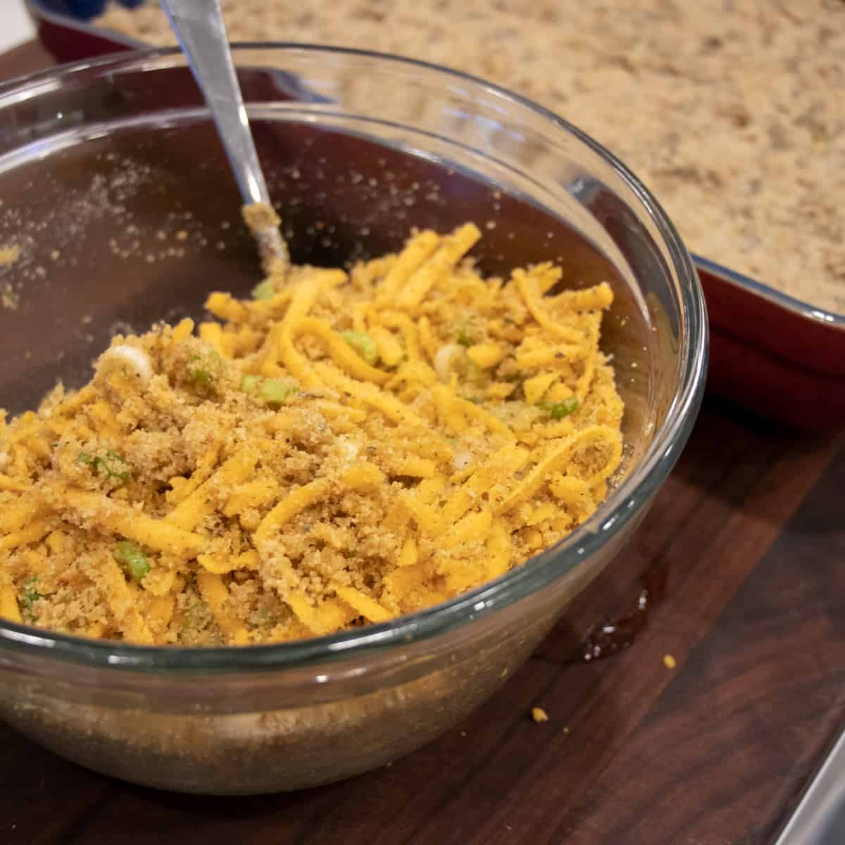 Cheesy crumble topping in a glass mixing bowl.