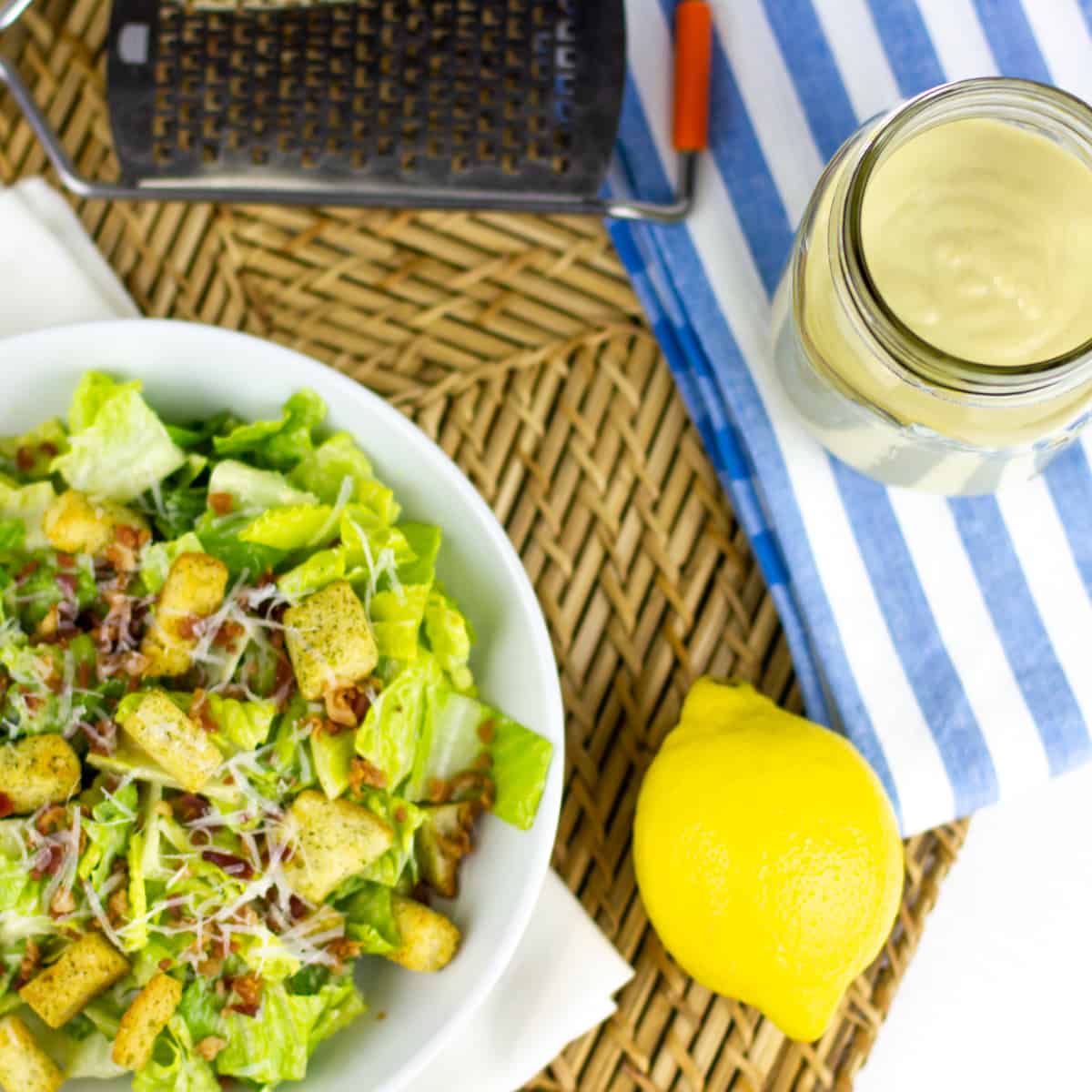 Overhead picture of Caesar salad and a jar of salad dressing.