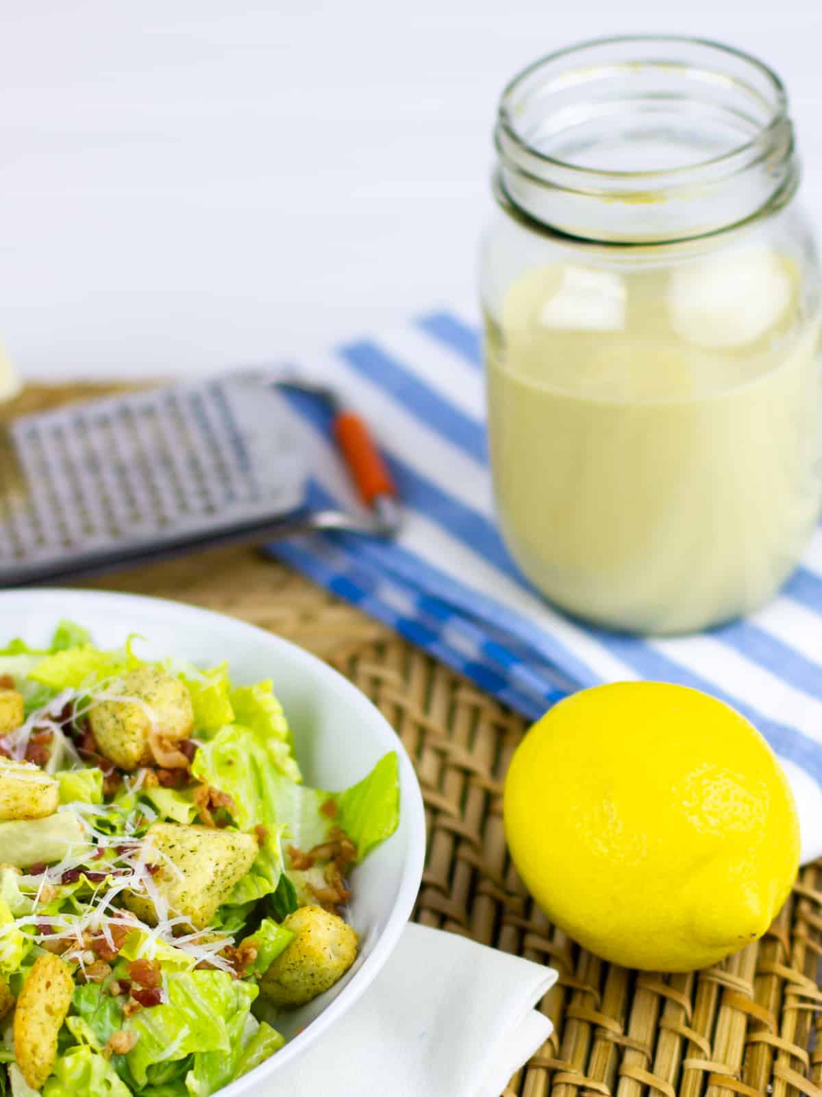 Fresh salad with croutons next to a whole lemon.