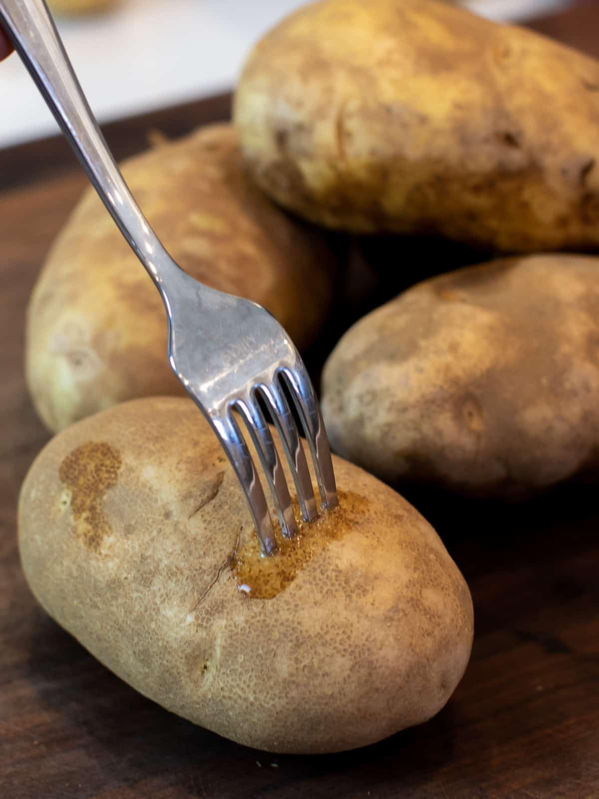 A fork stuck into a russet potato.