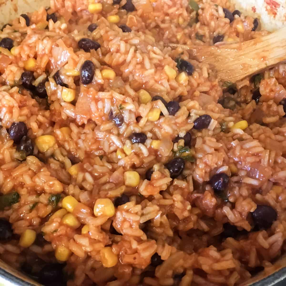 Cooked rice with black beans and corn in a pot.