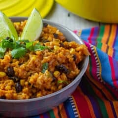 A bowl of cooked rice with lime wedges