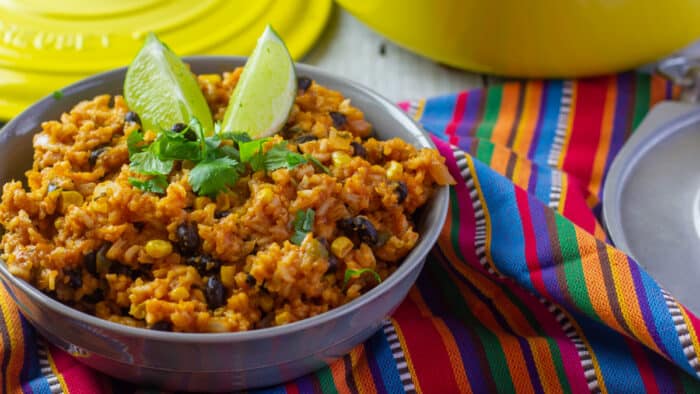 A bowl of cooked rice with lime wedges