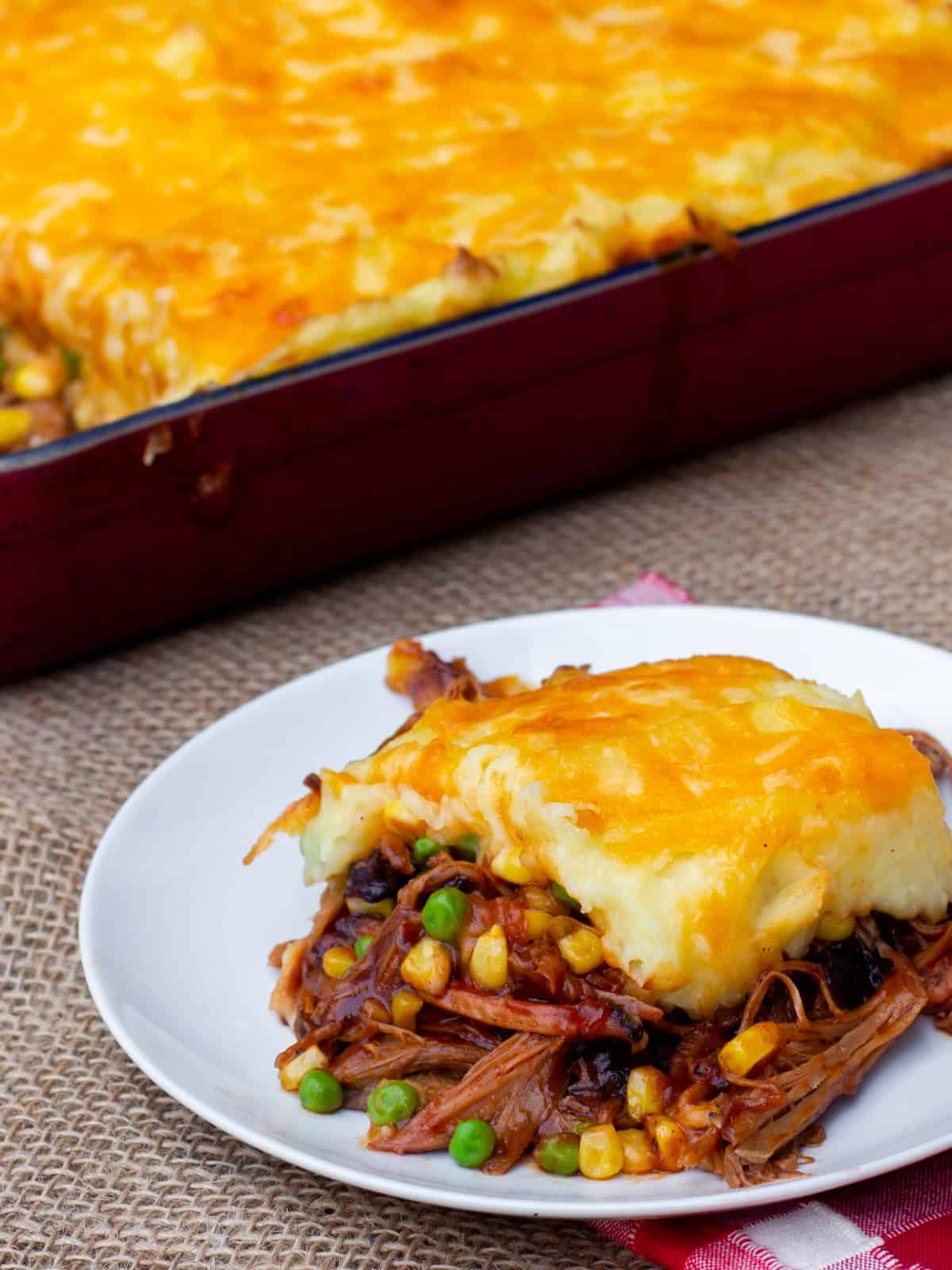 Shepherd's pie in a baking dish and one portion on a plate.