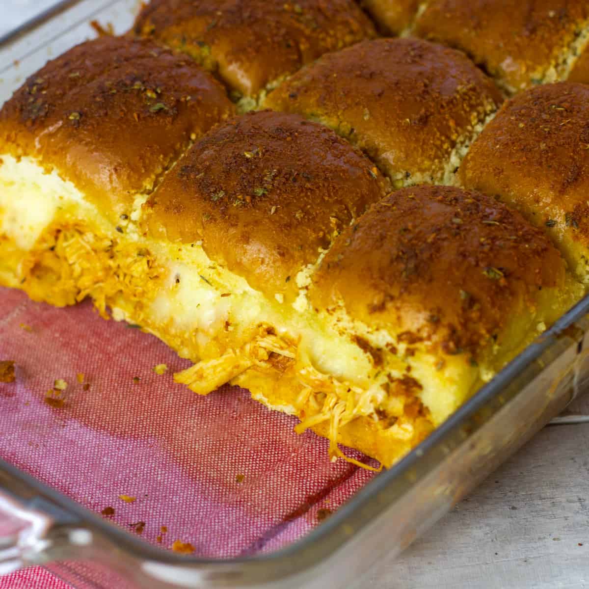 A baking dish with chicken sliders.