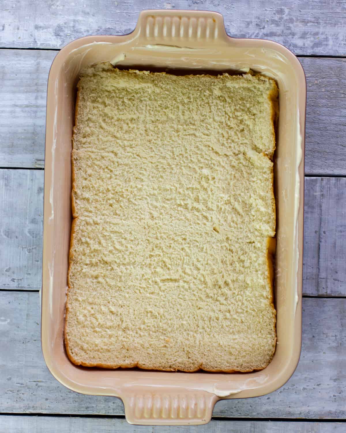 Bottom half of dinner rolls in a baking dish.