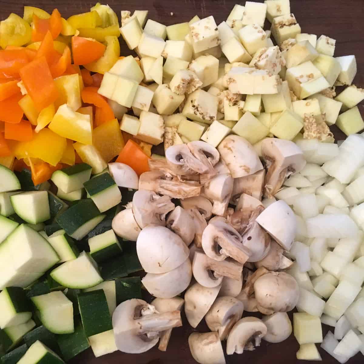 Zucchini, eggplant, mushrooms and other vegetables all cut into cubes.