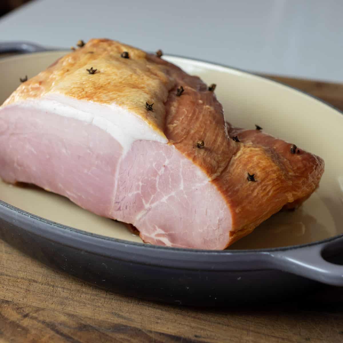 Ham in a baking dish with whole cloves.