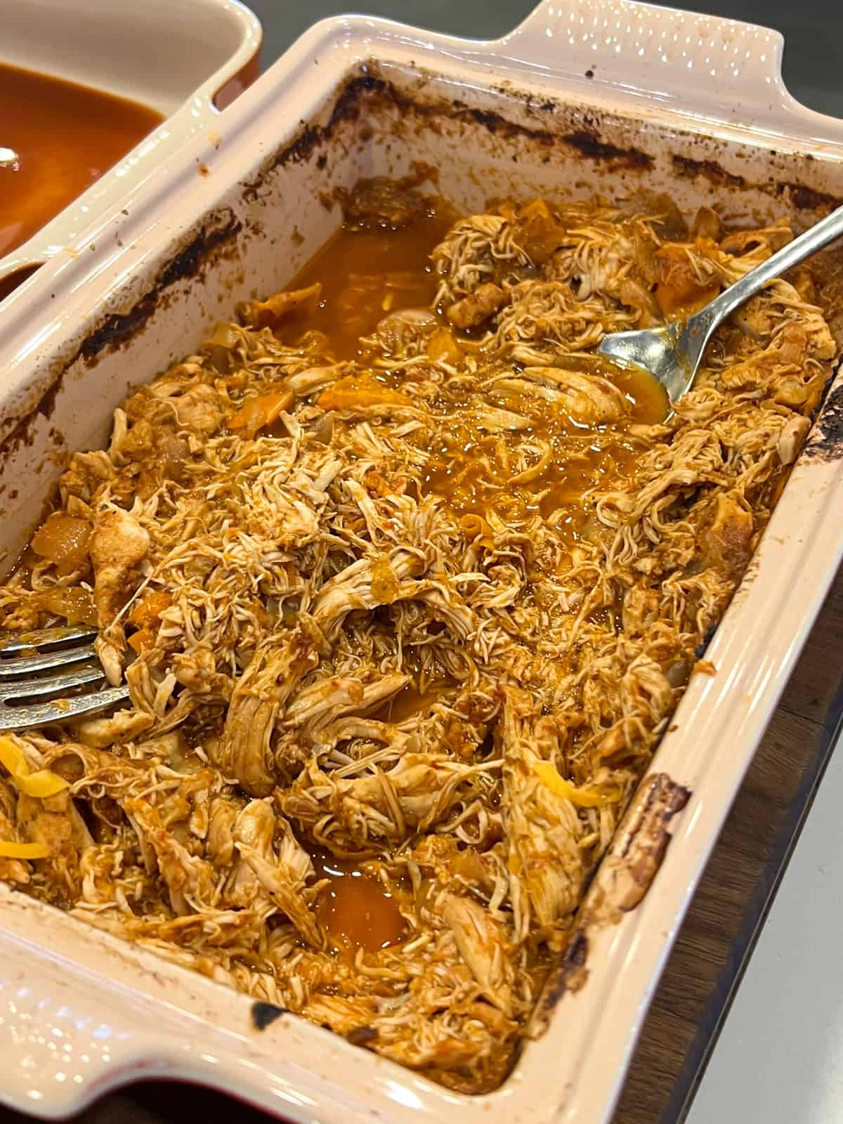 Shredded chicken meat in a baking dish.