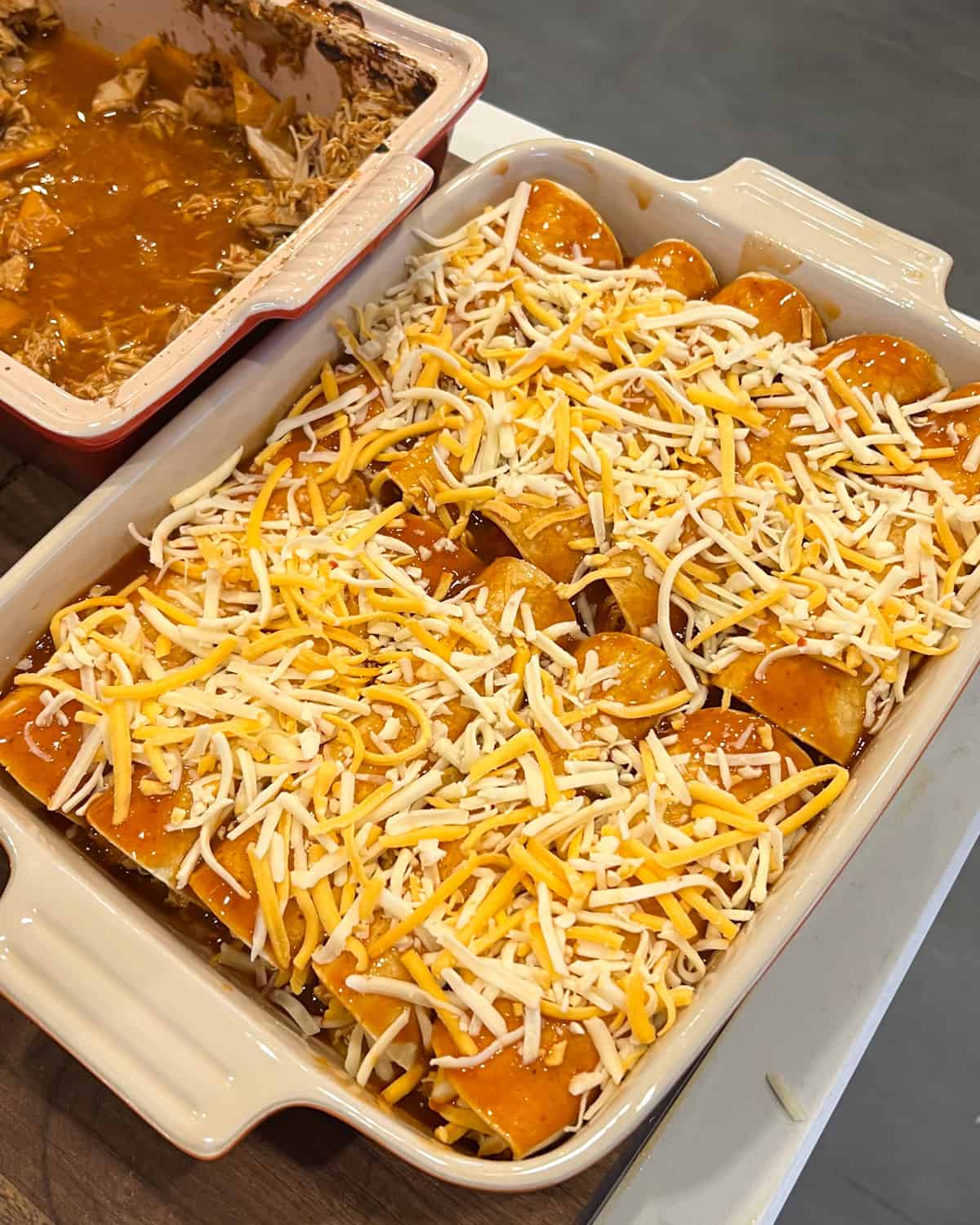 Enchiladas with grated cheese sprinkled on top.